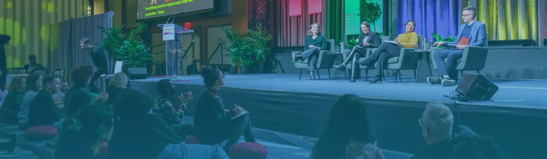 ArtsRx Session at APAP|NYC 2025. The photo includes audience members seated on the floor and four panelists onstage discussing the impact of the arts on community well-being.